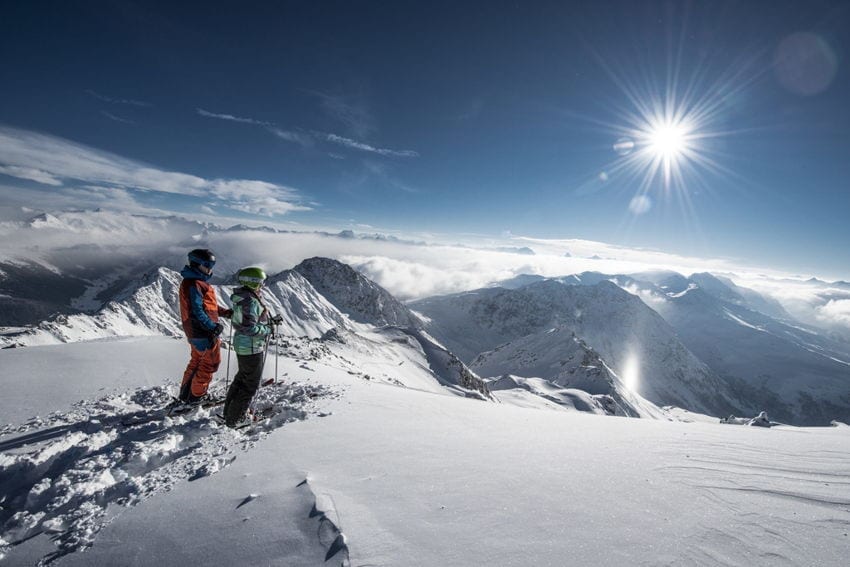 ein Skilehrer, der einer Frau die Berge zeigt