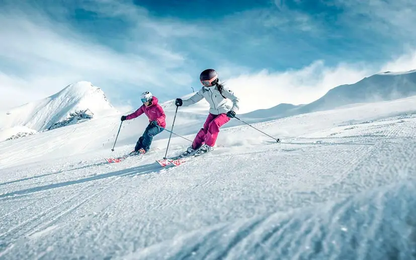 Private Skistunde in St. Moritz mit zwei Frauen unter einem blauen Himmel.