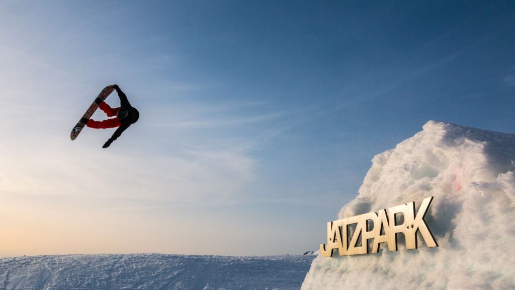 A snowboarder jumps over a large ramp during a freestyle course at the Davos Klosters Snowboard Schoo