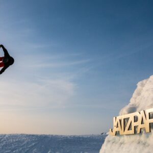 A snowboarder jumps over a large ramp during a freestyle course at the Davos Klosters Snowboard Schoo