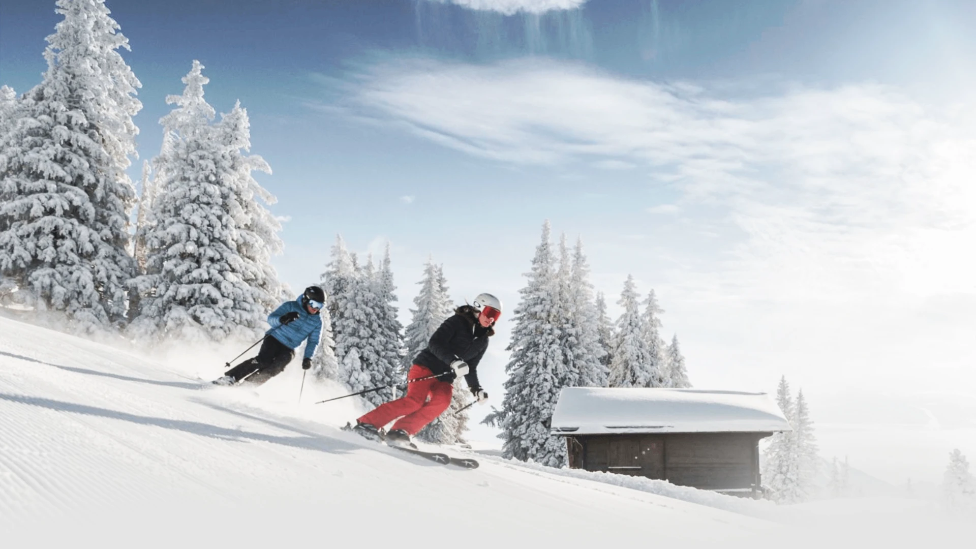 Two skiers during a carving lesson with the Davos Ski School in Davos, with a barn in the photo