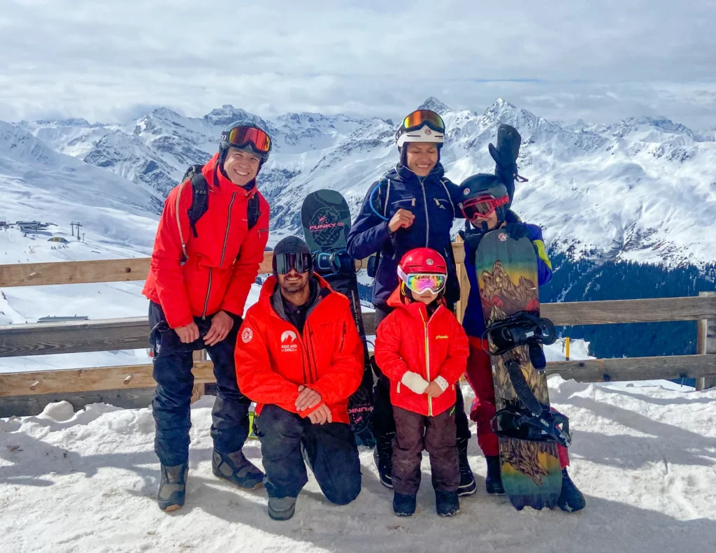 A family with a snowboard instructor during a private snowboard lesson with the Davos Snowboard School