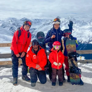 A family with a snowboard instructor during a private snowboard lesson with the Davos Snowboard School